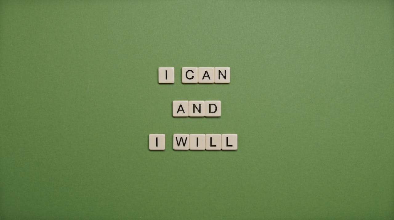 Inspirational message 'I Can and I Will' spelled with tile letters on a green background.